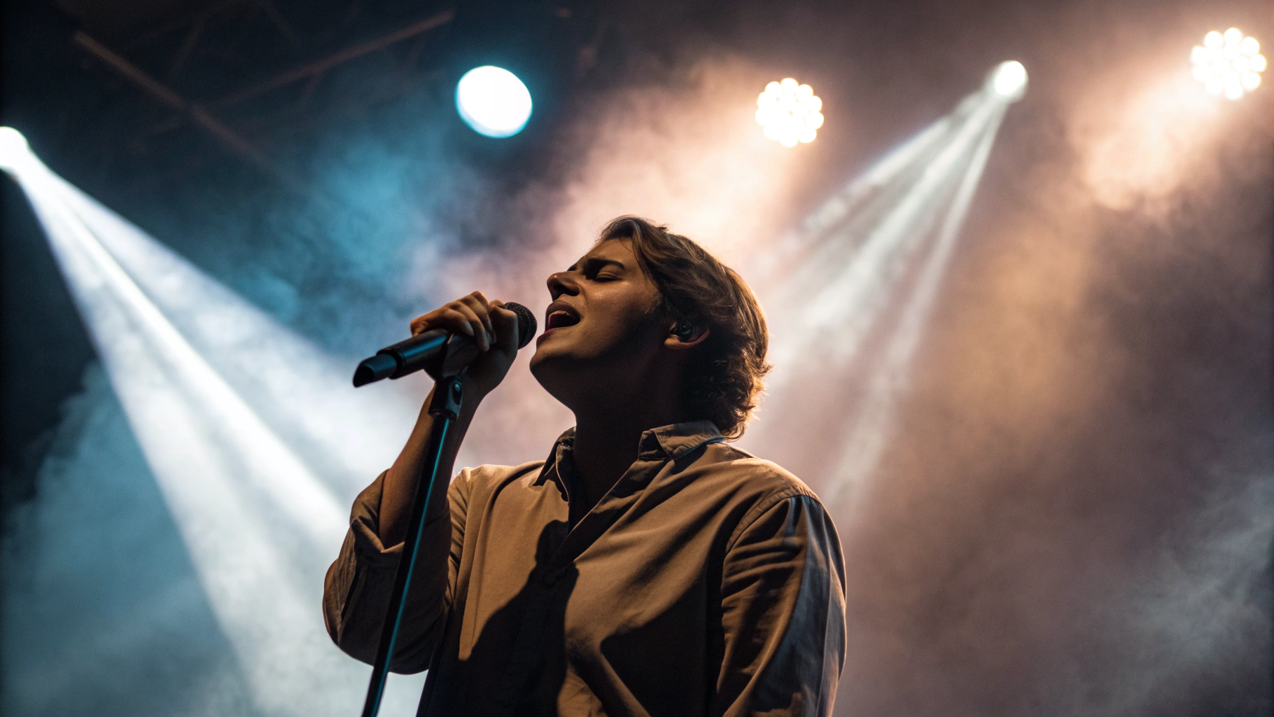 Крупный план на сцене с 5x: прожектора и дым, лицо артиста в фокусе