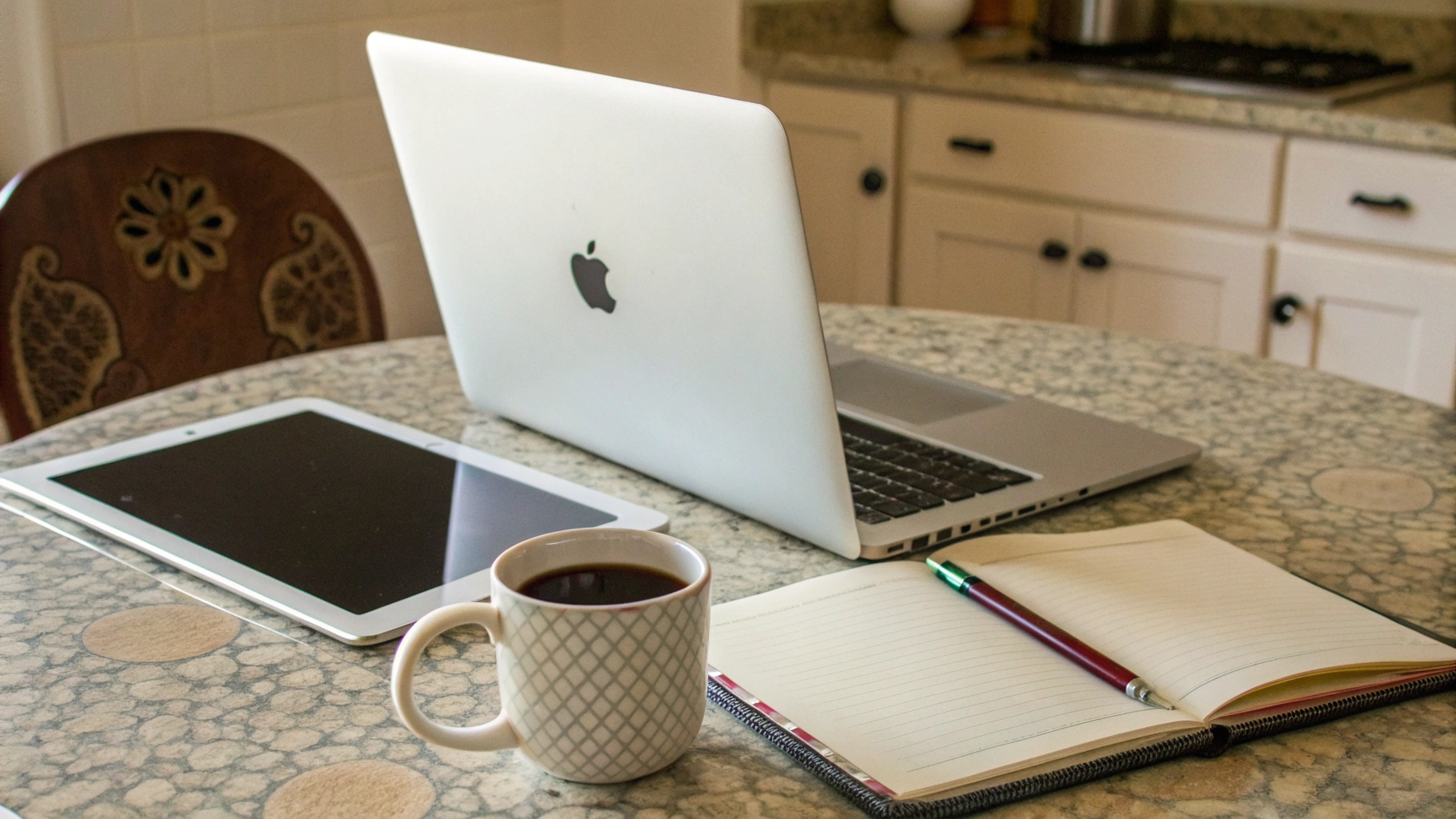 MacBook и iPad на небольшом кухонном столе в домашнем офисе