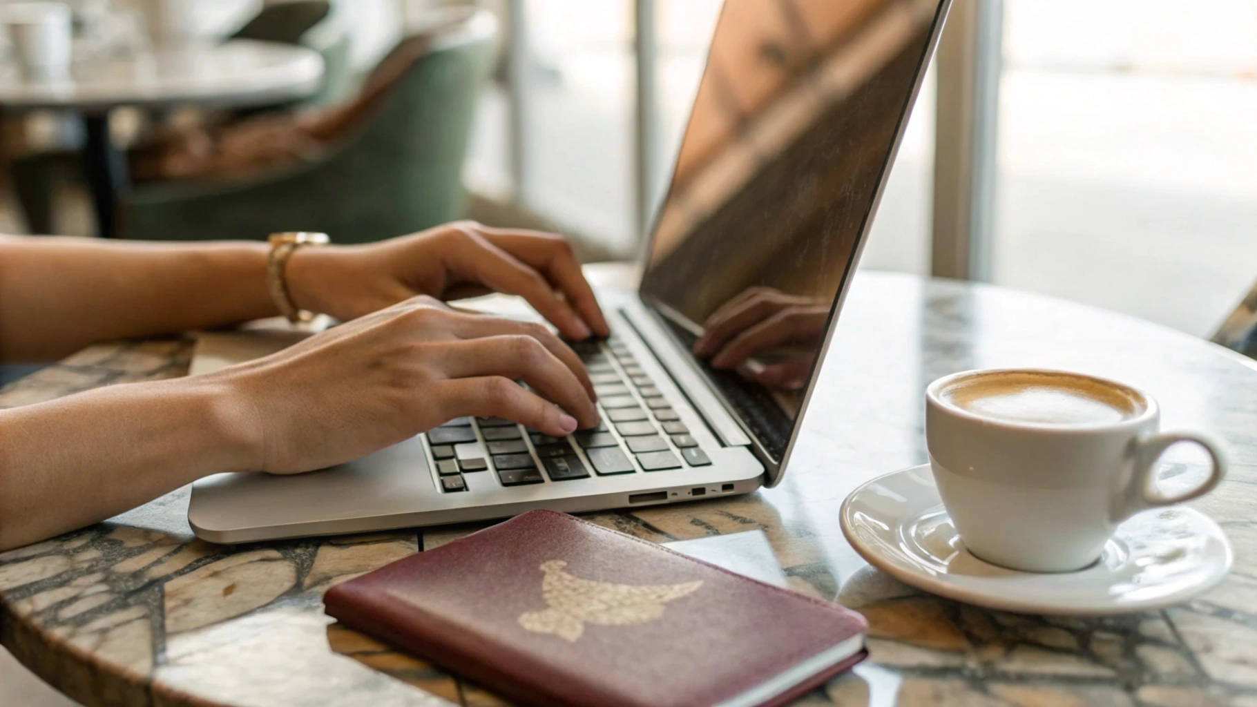 Работа на тонком ноутбуке в кафе во время поездки, рядом чашка и паспорт