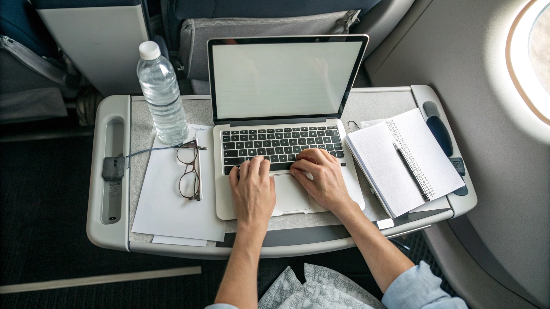 Ноутбук на раскладном столике в самолёте во время работы в полёте