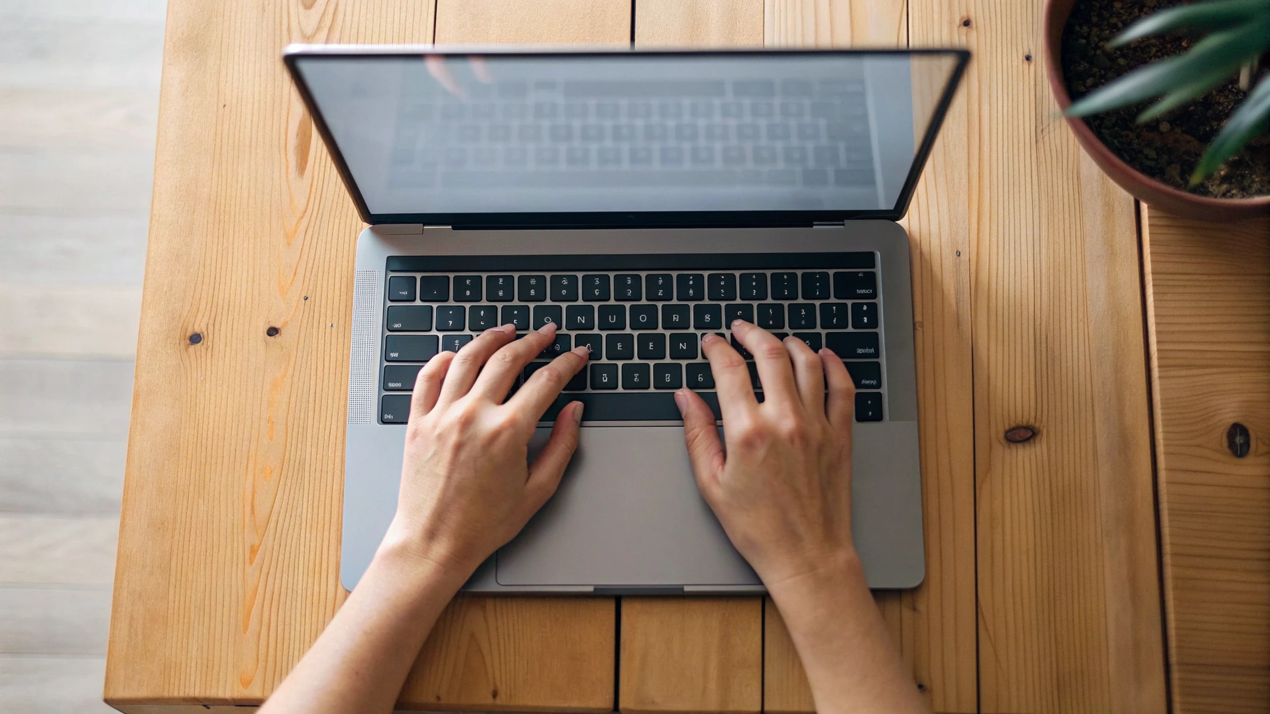 Руки печатают на клавиатуре 14-дюймового ноутбука с большим тачпадом