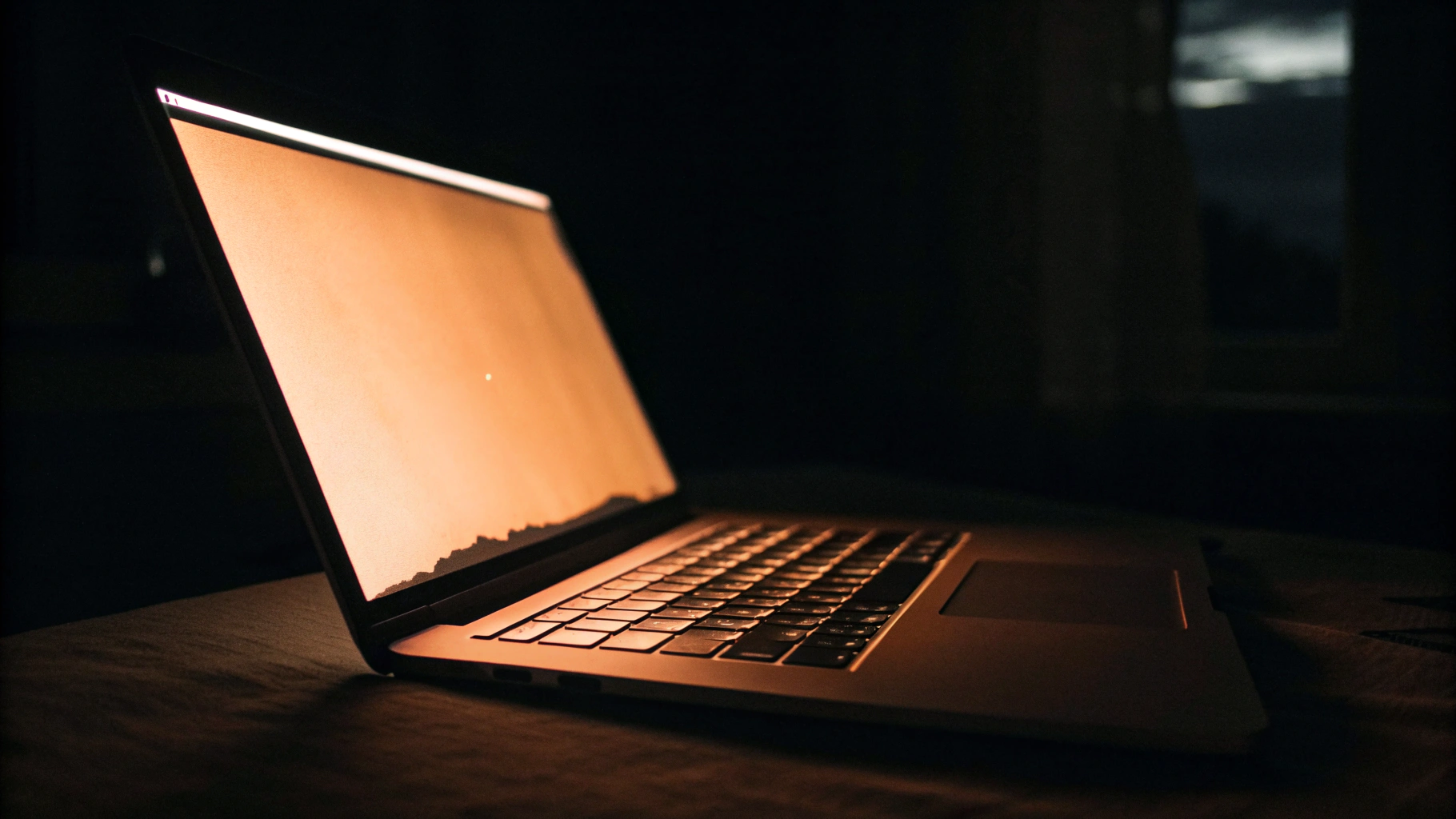 Экран MacBook с приглушённой яркостью и тёплым оттенком для работы ночью