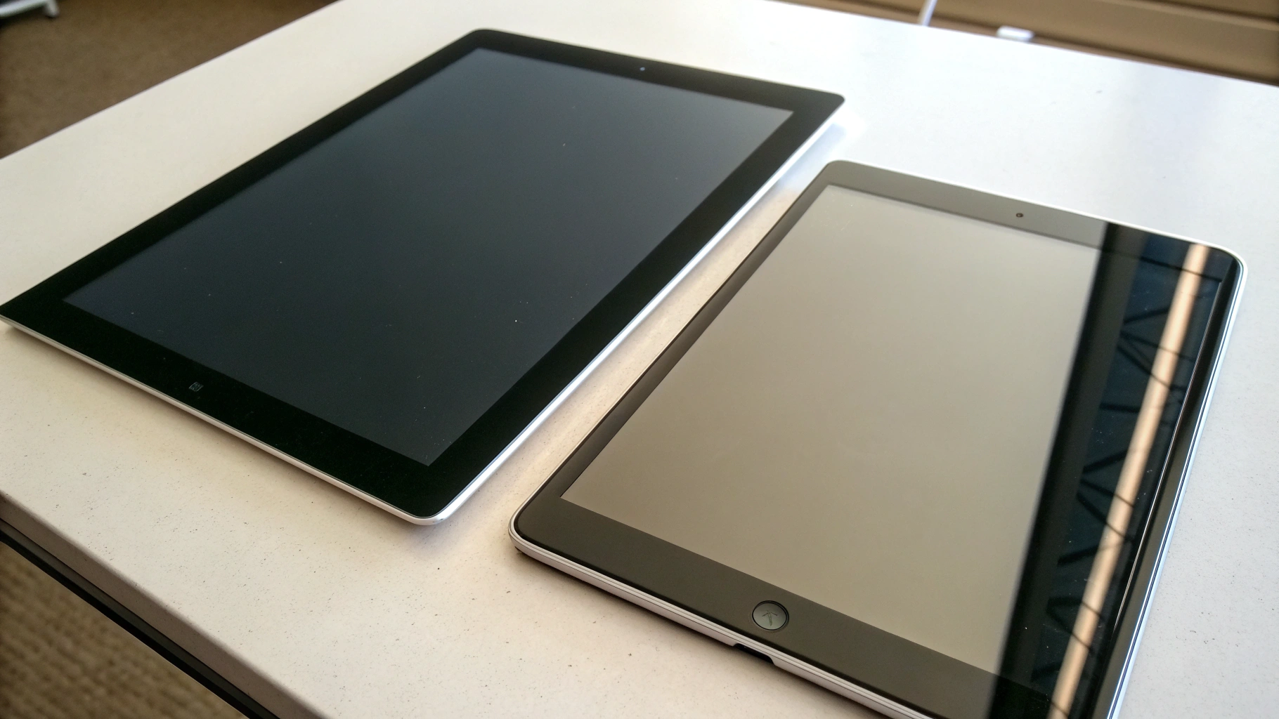 Два планшета на столе с разным размером шрифта и типом экрана для сравнения удобства чтения