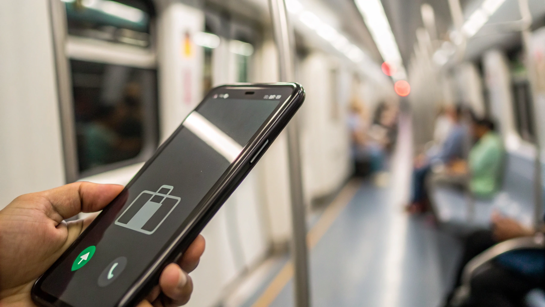 Смартфон с иконками заряда батареи и сигнала связи в движущемся поезде
