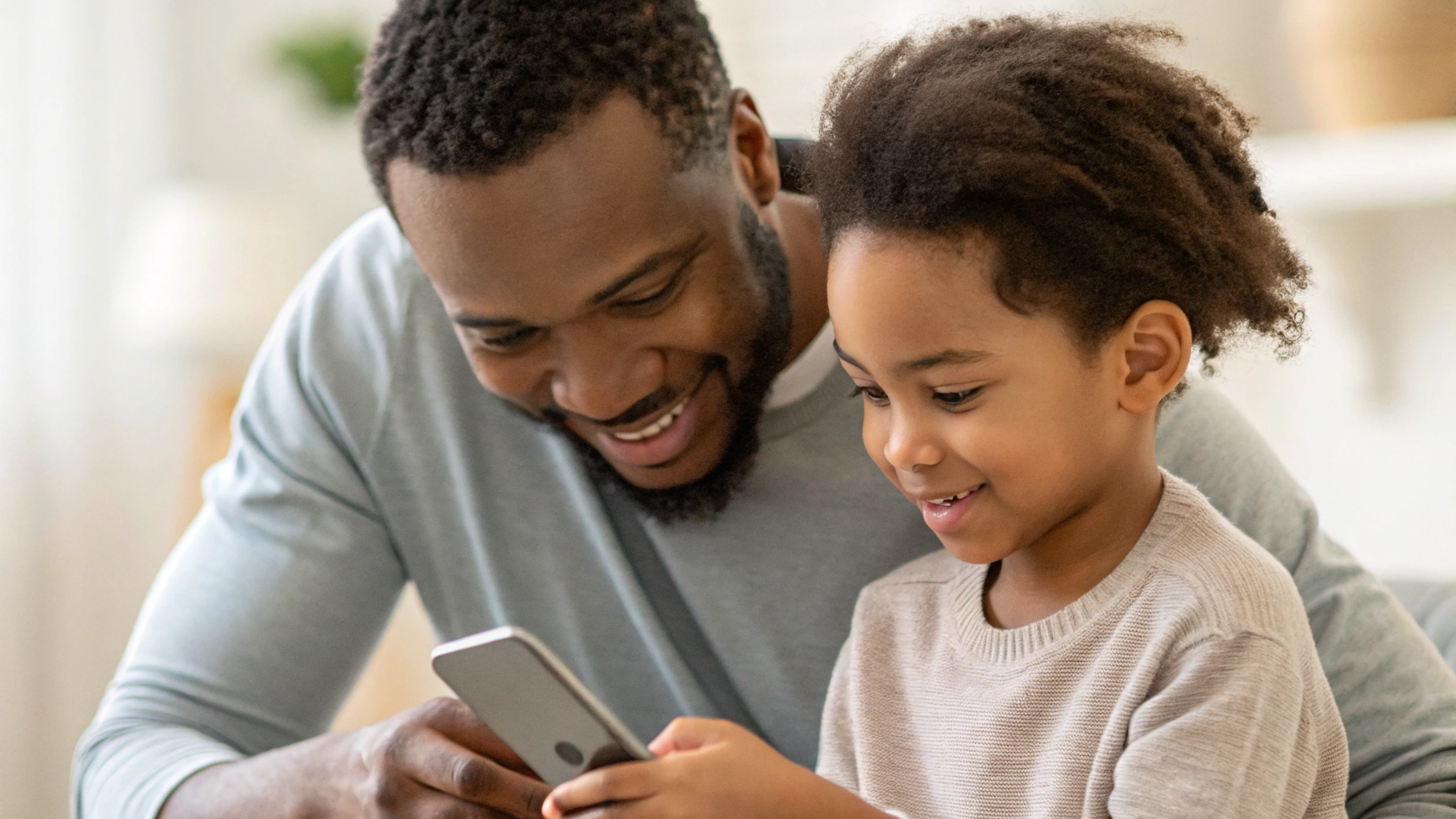 Родитель и школьник вместе смотрят на экран смартфона и настраивают лимиты времени и учебный режим