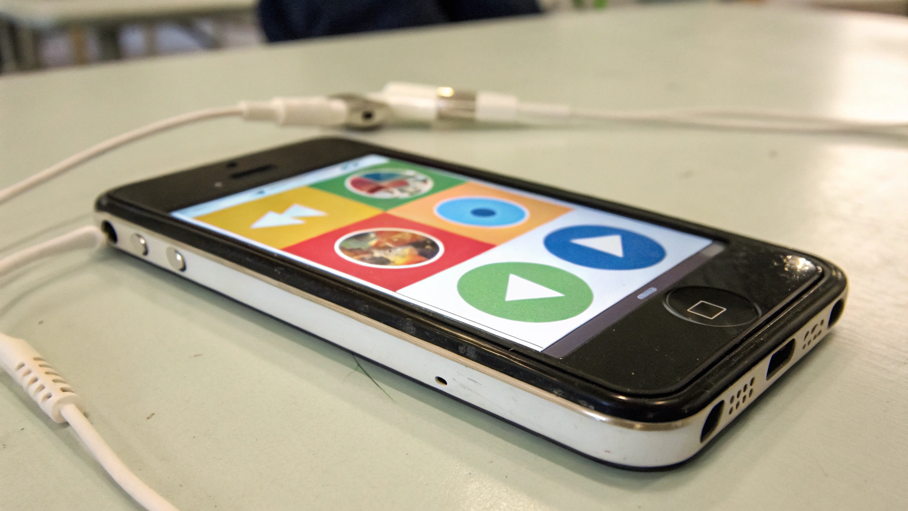 Старый смартфон на столе с простым интерфейсом детского аудиоплеера