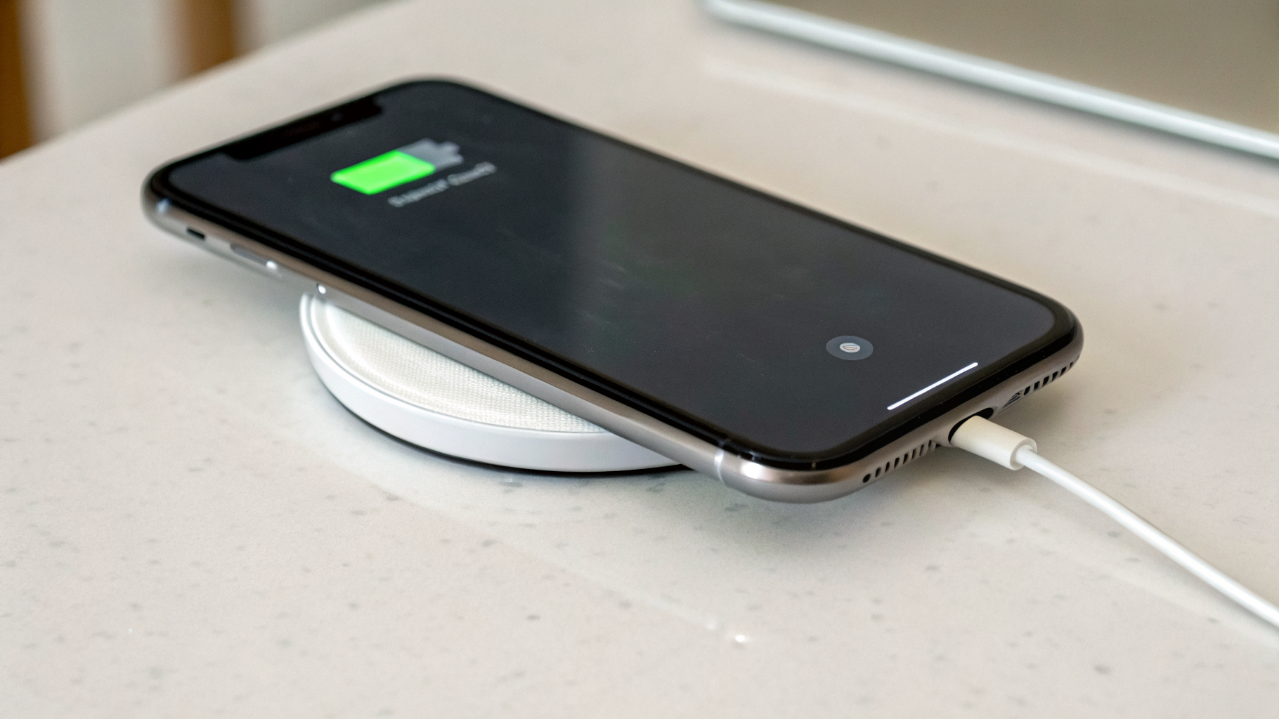 Тест зарядки MagSafe: iPhone лежит на зарядке, на экране видна индикация зарядки