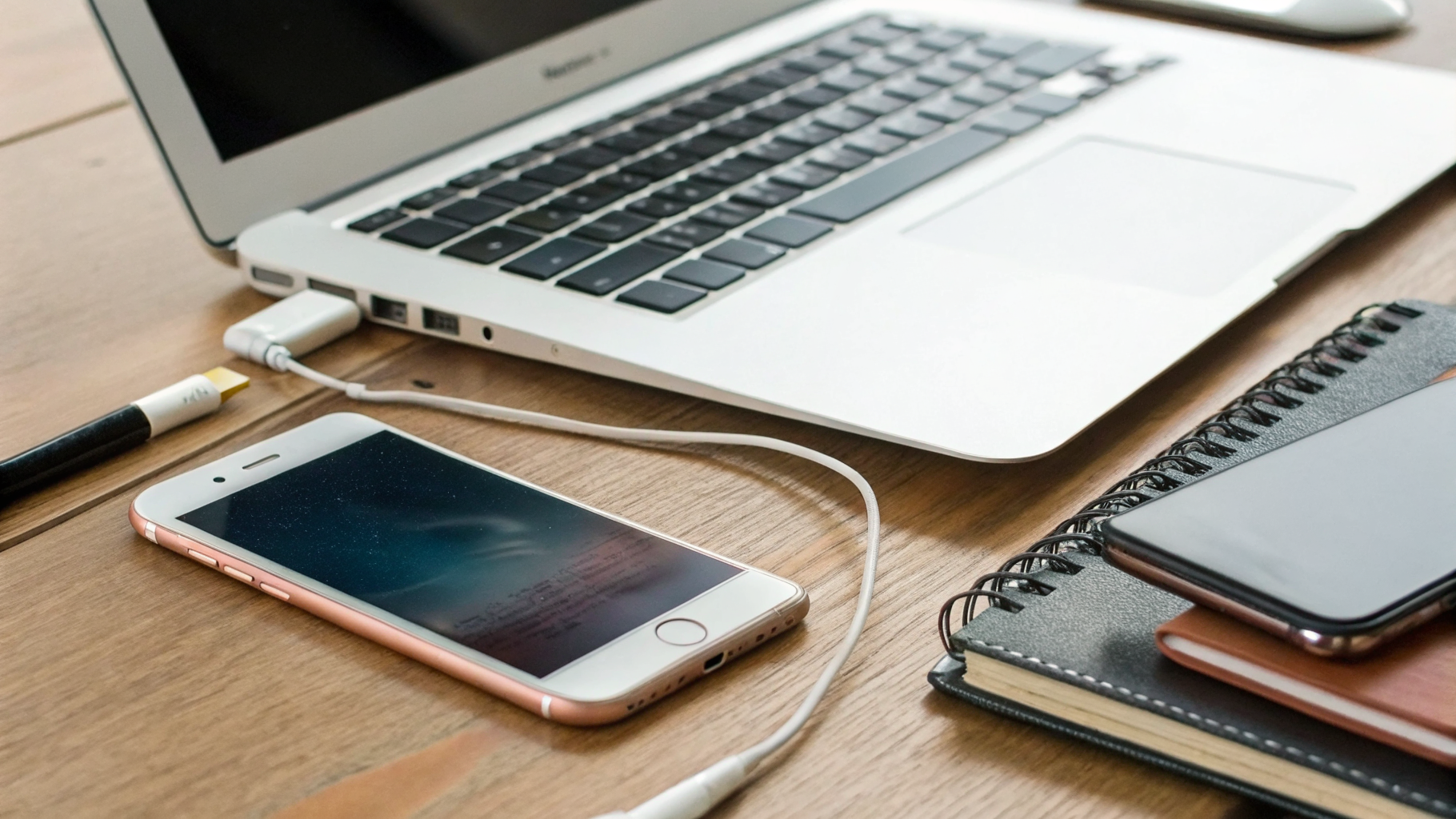 Смартфоны iPhone и Samsung рядом с ноутбуком на рабочем столе